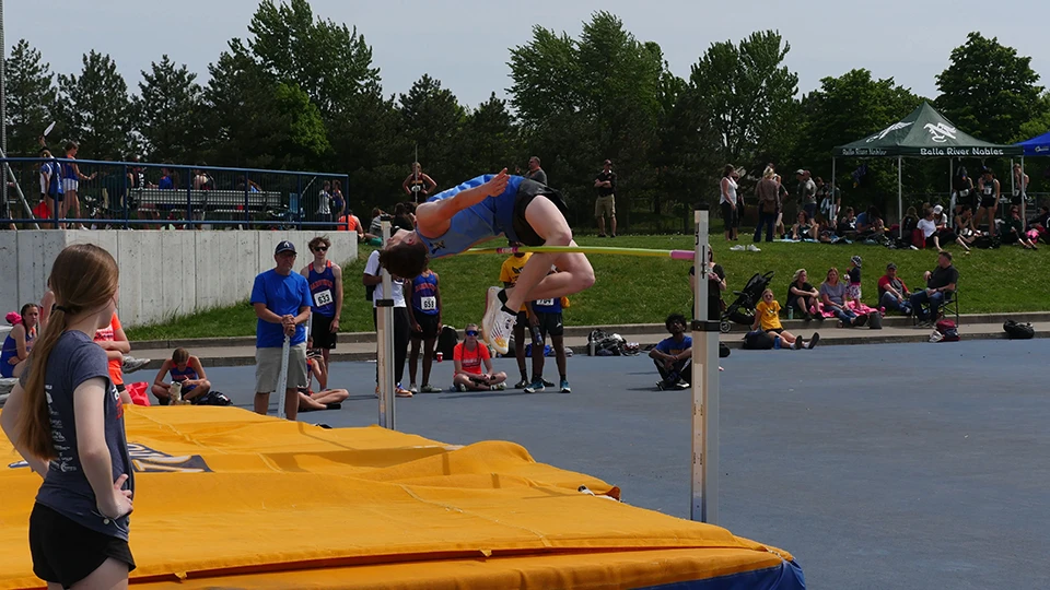 high jumper mid jump over top of the bar