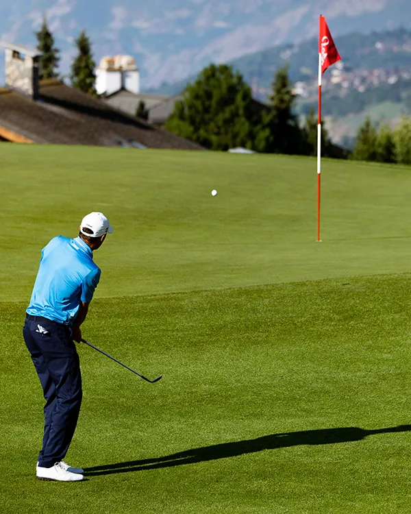 man in blue shirt playing golf